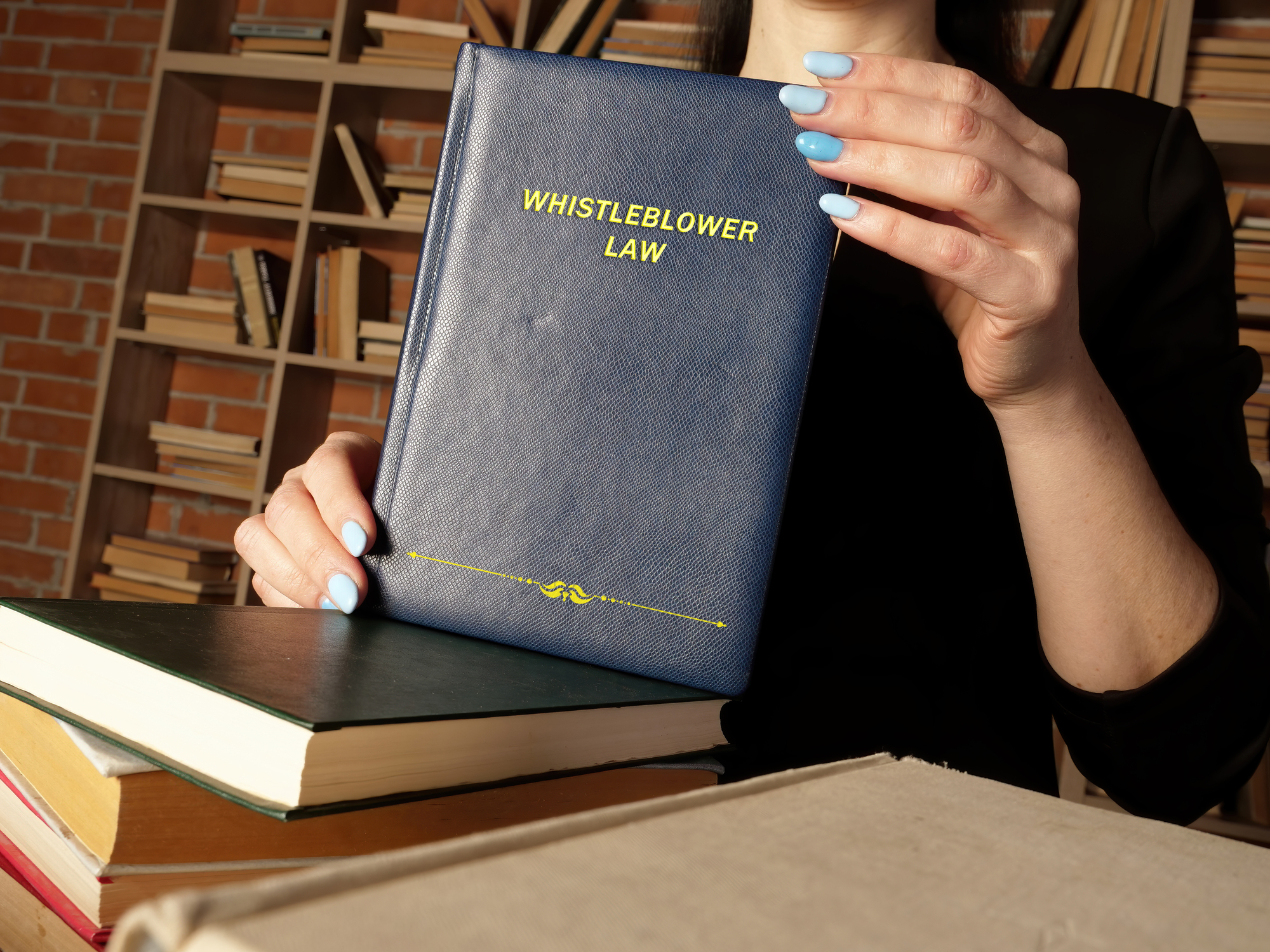 Whistleblower Protections Explained - Attorney holds WHISTLEBLOWER LAW book. As a whistleblower you'
