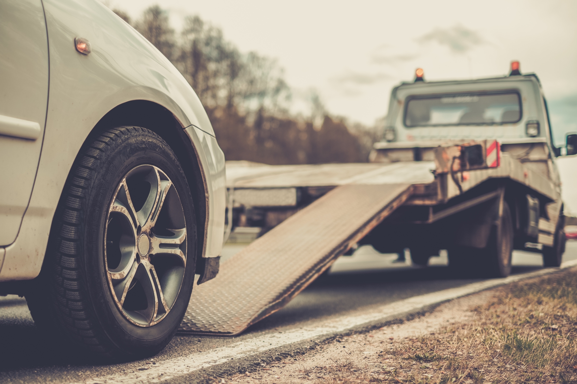 Finding The Right Car Accident Lawyer - Loading broken car on a tow truck on a roadside